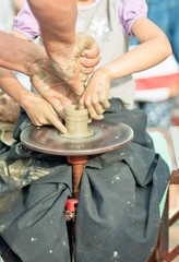 Hands working on pottery wheel