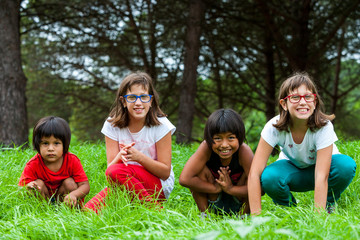 Fototapeta na wymiar Cute girls sitting in green grass field.