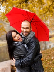 Happy middle-aged couple with umbrella outdoors