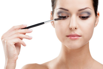 Woman putting on make up with cosmetic brush