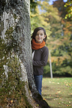 Girl Looking From Behind A Tree