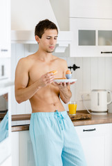 Half-naked man has breakfast at kitchen