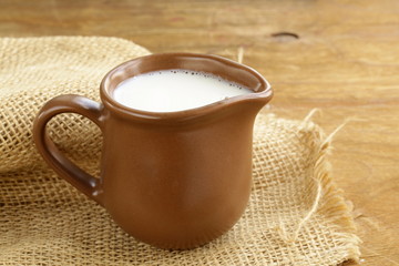 ceramic brown  jug full of milk, rustic style