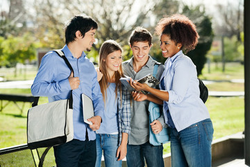 Students Discussing Over Book In University Campus