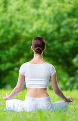 Backview of woman who sits in asana position zen gesturing