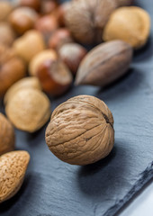 a walnut in front of a nut mixtur
