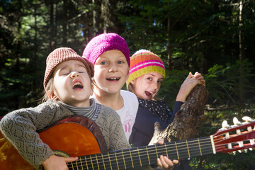 Group of children singing and playing guitar together in the for