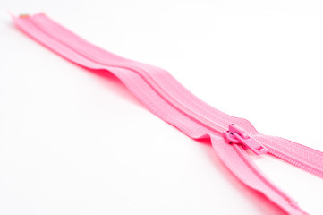 Obraz na płótnie Canvas detail of pink zipper on the white background