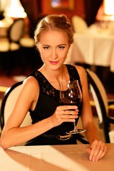 Beautiful young girl with glass of red wine