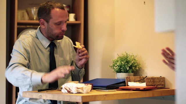 Businessman eating breakfast and reciving sandwich kissing wife