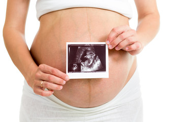 pregnant woman holding ultrasound scan on her belly