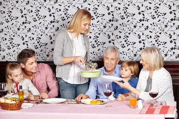 Mother serving food to family at dinner