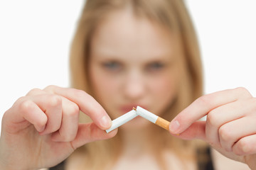 Close up of a woman breaking a cigarette