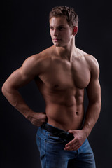 Fototapeta na wymiar Muscle sexy naked young man posing in jeans
