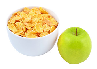 Green apple and bowl of cornflakes