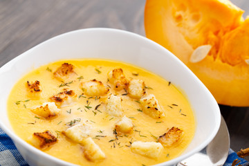 Pumpkin soup in white bowl