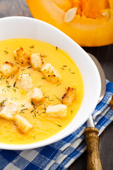 Pumpkin soup in white bowl