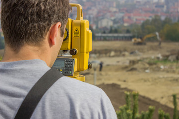 Land surveyor behind theodolite