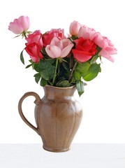 pink roses in brown ceramic jug