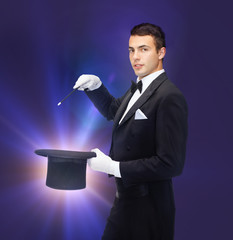 magician in top hat with magic wand showing trick