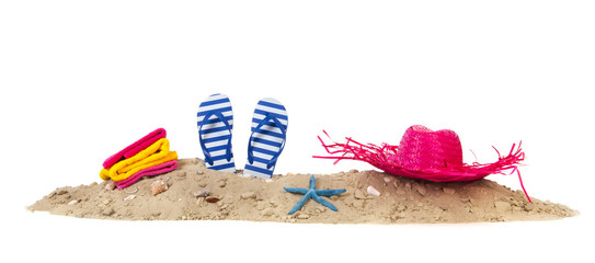 Beach sand with towels flip flops and hat