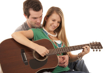 Young couple in love sitting playing guitar
