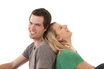 Young couple leaning back to back laughing