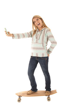 Young girl skateboarding taking selfies