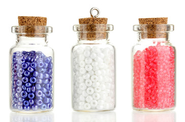 Little bottles full with colorful beads isolated on white