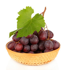 Ripe delicious grapes in wicker basket isolated on white