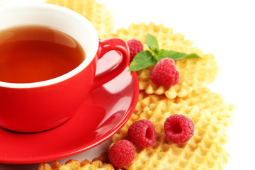 Cup of tea with cookies and raspberries close-up