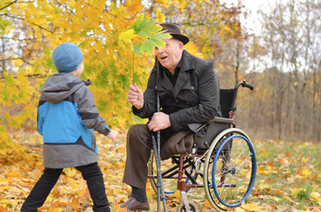 Young boy playing with his disabled grandfather