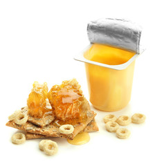 Tasty dessert in open plastic cup and honey combs, isolated
