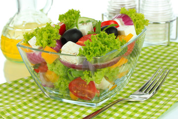 Greek salad on plate on table on white background