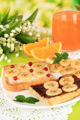 Delicious toast with bananas on plate close-up