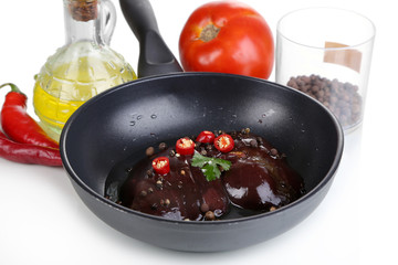 Raw liver in pan with spices and condiments isolated on white