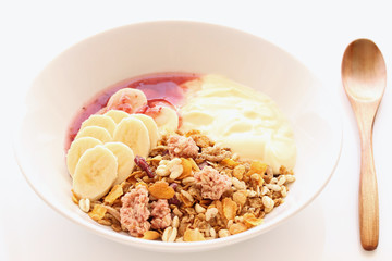 Granola, banana, yoghurt and raspberry jam for healthy breakfast