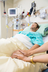 Fototapeta premium Woman Holding Man's Hand Lying On Bed
