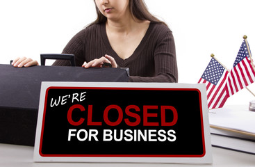 woman with a desk sign showing closed for business