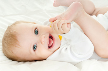 happy baby playing with his feet