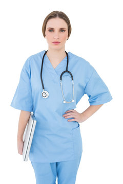 Young female doctor holding a notebook and looking into the came