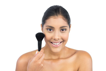 Smiling nude brunette holding powder brush