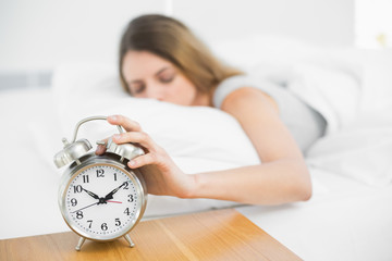 Brunette calm woman lying on her bed with eyes closed