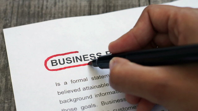 Circling Business Plan with a red marker