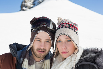Fototapeta na wymiar Couple in woolen hats on snow covered landscape