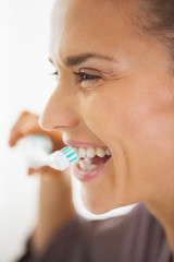 Happy young woman brushing teeth