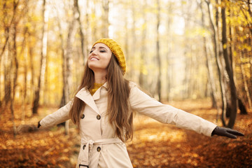 Fototapeta na wymiar Young woman enjoying nature at autumn