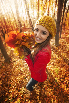 Happy woman have fun with leaves during the autumn