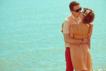 Couple walking on beach. Young happy married hipsters kissing