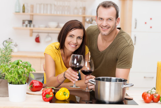 gl&uuml;ckliches paar st&ouml;&szlig;t mit rotwein an